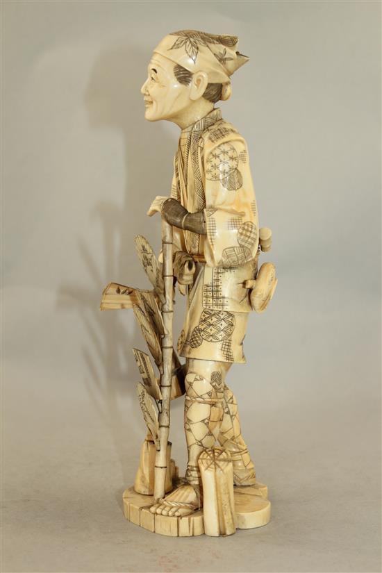 A Japanese sectional walrus ivory figure of a fan seller, early 20th century, 27.5cm